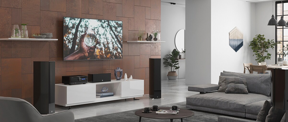 Image of AV receiver and passive speaker in a spacious room to visualize the use case of MusicCast